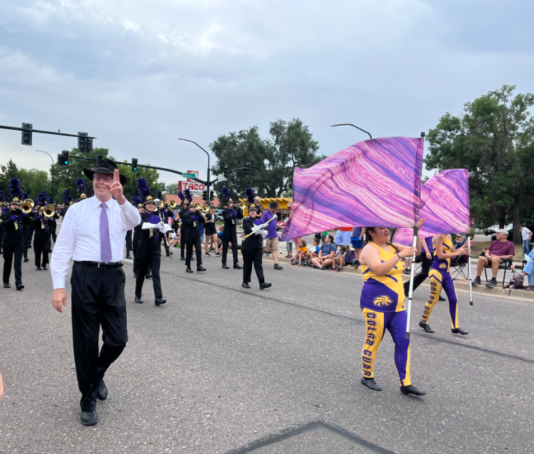 Marching band and color guard members march in the parade